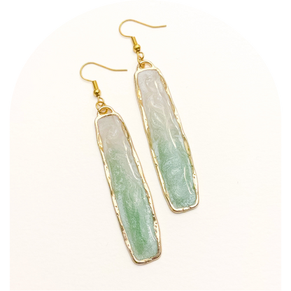 Green stone earrings with gold accents on a white background