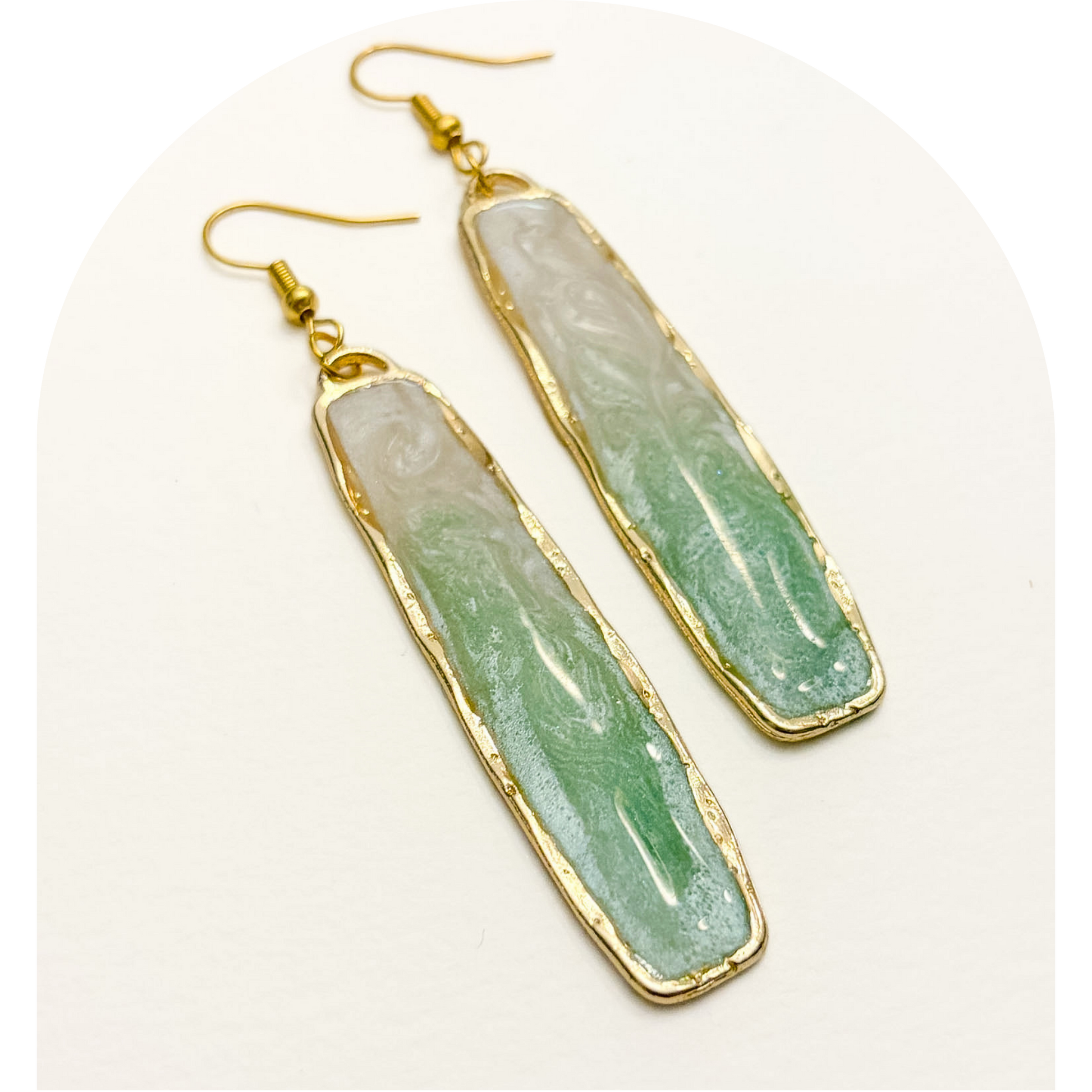 Green stone earrings with gold accents on a white background